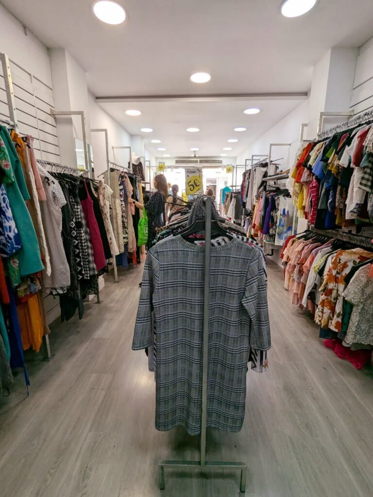 Colorful racks of secondhand clothing at Humana, showcasing a variety of styles and fabrics.