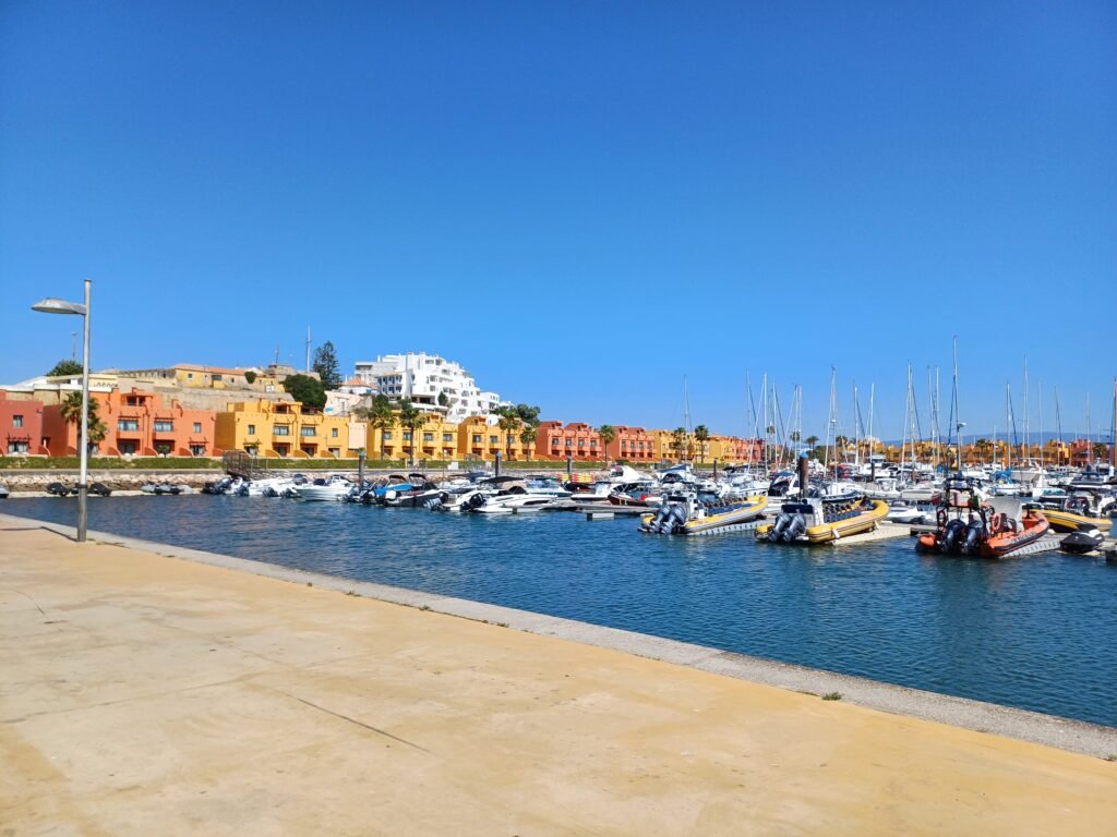 Portimão Marina with colorful houses and boats docked along the waterfront.