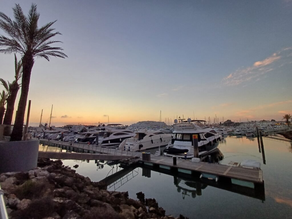 Sunset over Vilamoura Marina with boats parked at the docks