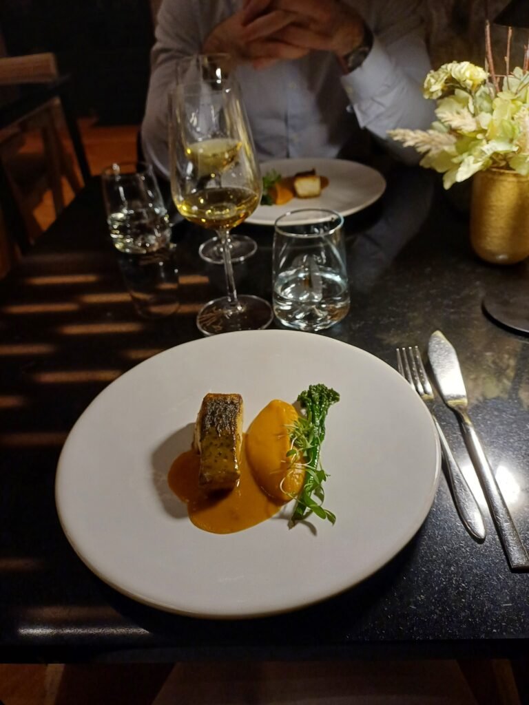 A beautifully plated main course featuring tender fish that melts in the mouth.