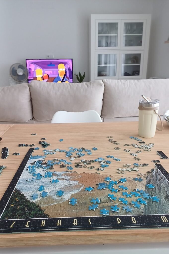 jigsaw puzzle on a dining table; tv with a relaxing playlist on the background